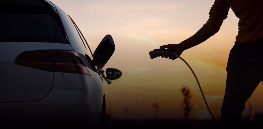 A person is plugging in an electric car